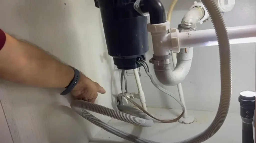 Preparing the drain hose by pulling as much as possible from dishwasher side 