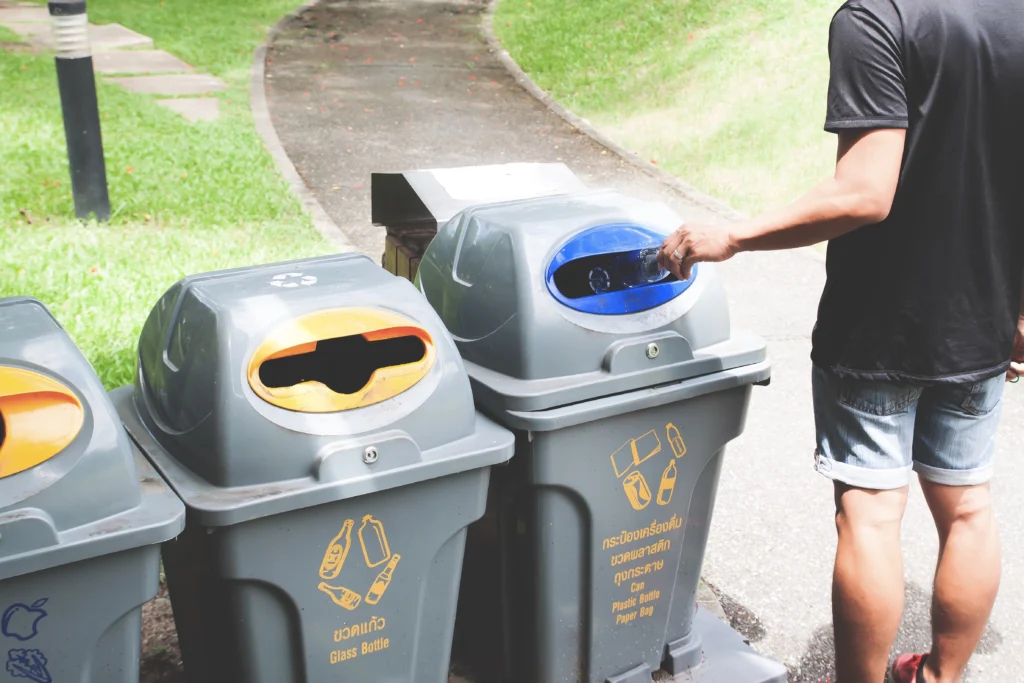 man throwing metal scrap in the recycling bin